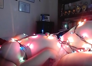 Chubby girl hangs out on touching christmas lights
